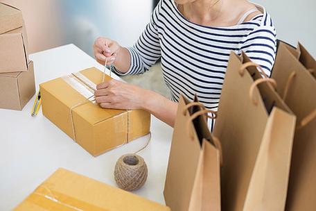 工作网上购物的企业主妇女在她的家,年轻企业家概念准备产品包装过程